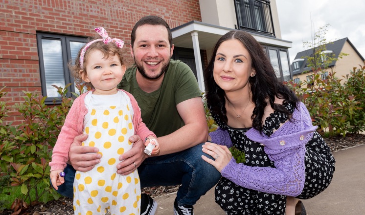 Family smiling outside home